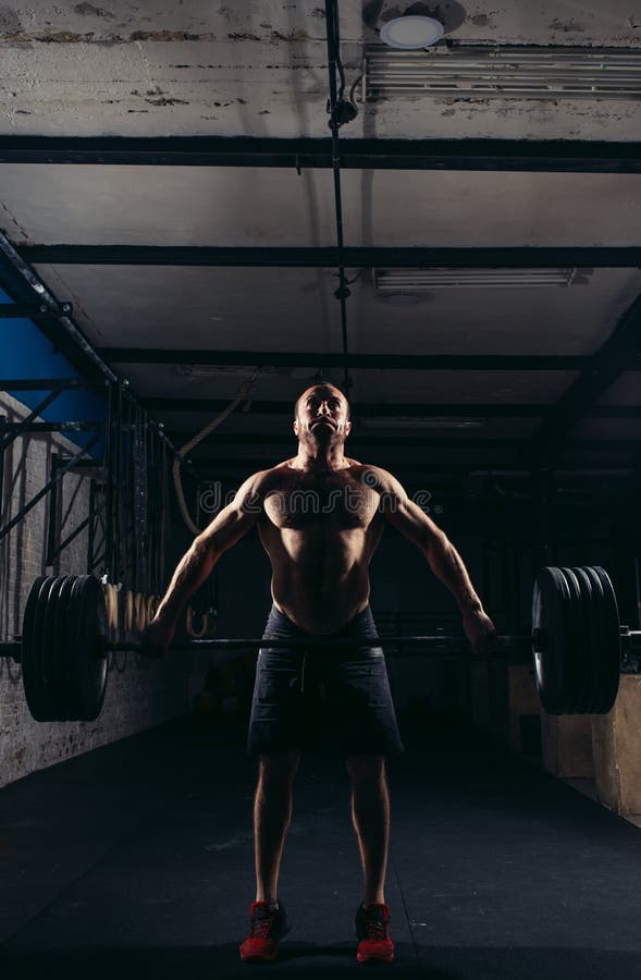 Barre de levage lourde de gymnase de forme physique de Crossfit par séance d'entraînement d'homme fort photo stock Barre de levage lourde de gymnase de forme physique de Crossfit par séance d'entraînement d'homme fort photo stock