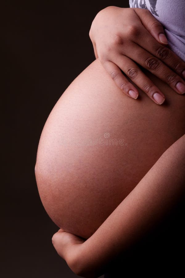 Barriga afro-americano grávida da mulher dos jovens - pessoas negras