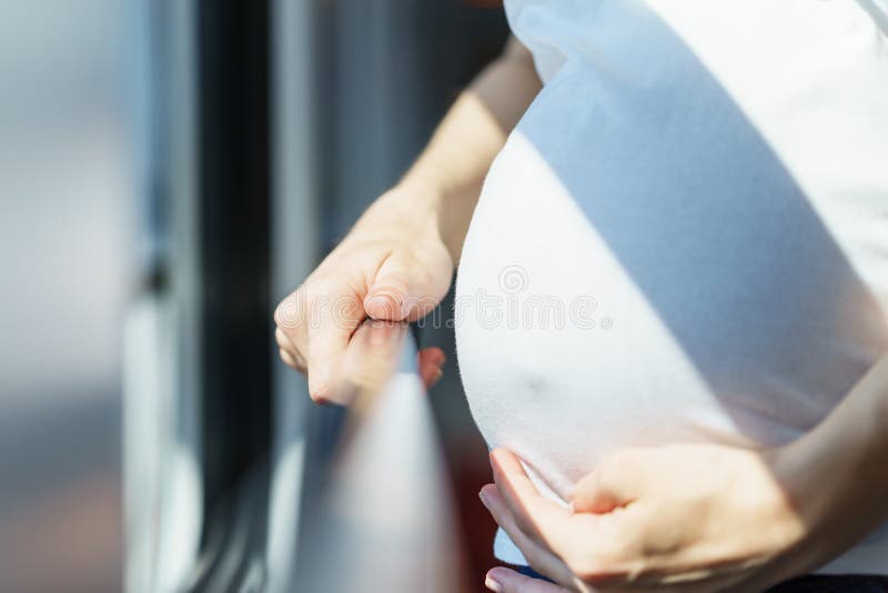 Barriga bonita de mulheres europeias grávidas perto da janela do trem quando ela que viaja pela maneira do trilho e que guarda o fotos de stock royalty free Barriga bonita de mulheres europeias grávidas perto da janela do trem quando ela que viaja pela maneira do trilho e que guarda o fotos de stock royalty free