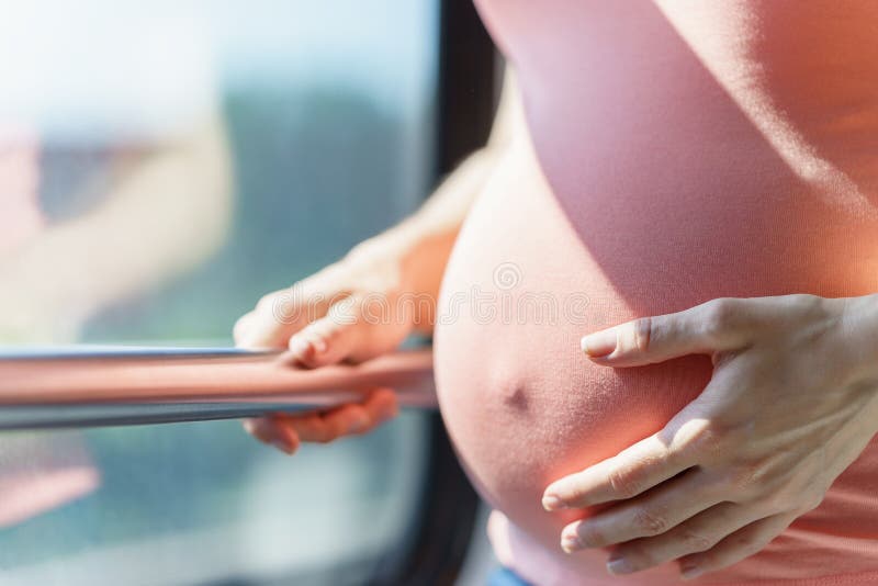 Barriga bonita de mulheres europeias grávidas perto da janela do trem quando ela que viaja pela maneira do trilho e que guarda o foto de stock Barriga bonita de mulheres europeias grávidas perto da janela do trem quando ela que viaja pela maneira do trilho e que guarda o foto de stock