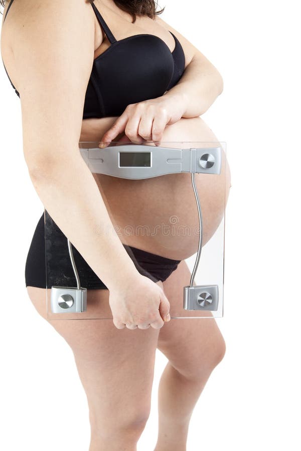 Barriga da mulher gravida que guarda o equilíbrio fotografia de stock Barriga da mulher gravida que guarda o equilíbrio fotografia de stock