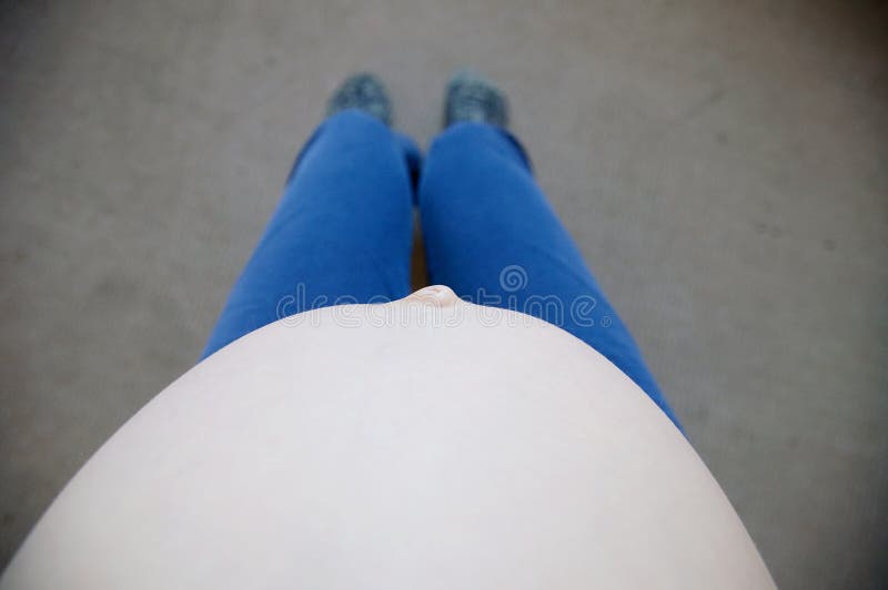 Barriga grávida da mulher de assento que relaxa no sofá opinião do selfie foto de stock royalty free Barriga grávida da mulher de assento que relaxa no sofá opinião do selfie foto de stock royalty free