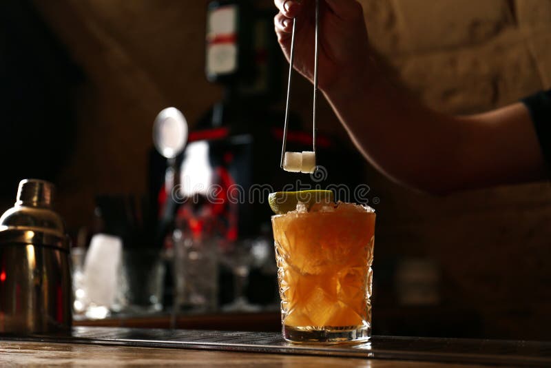 Bartender decorating glass of alcoholic cocktail at bar counter, closeup. Space for text royalty free stock photos Bartender decorating glass of alcoholic cocktail at bar counter, closeup. Space for text royalty free stock photos