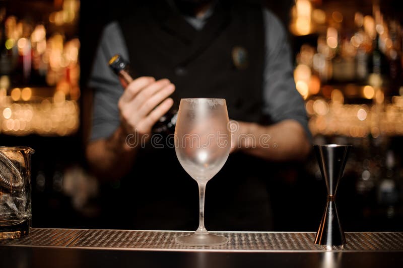 Bartender Holding a Bottle on the Foreground of Glass Stock Image