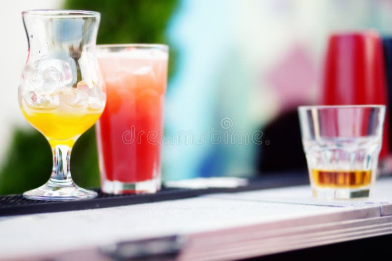 Bartender preparing a cocktail with yellow and red syrup stock photo Bartender preparing a cocktail with yellow and red syrup stock photo