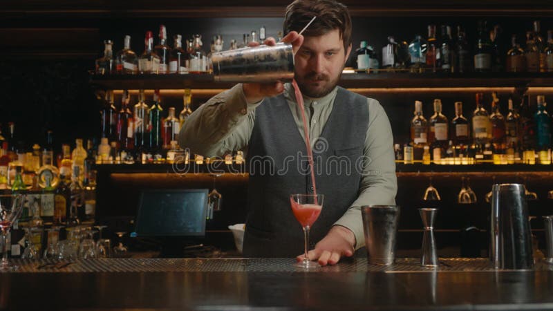 Bartender schmückt alkoholische Getränke in Cocktailglas an der Bar