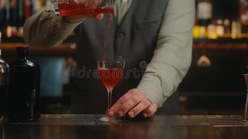 Bartender schmückt alkoholische Getränke in Cocktailglas an der Bar