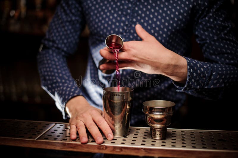 Bartender που χύνει μια μερίδα του ρόδινου ποτού οινοπνεύματος στο δονητή στοκ φωτογραφίες με δικαίωμα ελεύθερης χρήσης Bartender που χύνει μια μερίδα του ρόδινου ποτού οινοπνεύματος στο δονητή στοκ φωτογραφίες με δικαίωμα ελεύθερης χρήσης