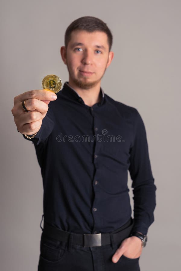Bartentrippe, die btc Goldmünze in handselektivem Fokus hält lizenzfreie stockfotografie