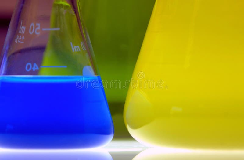 Three kinds of liquid dye (green, blue and yellow) in flasks and bottle. Three kinds of liquid dye (green, blue and yellow) in flasks and bottle