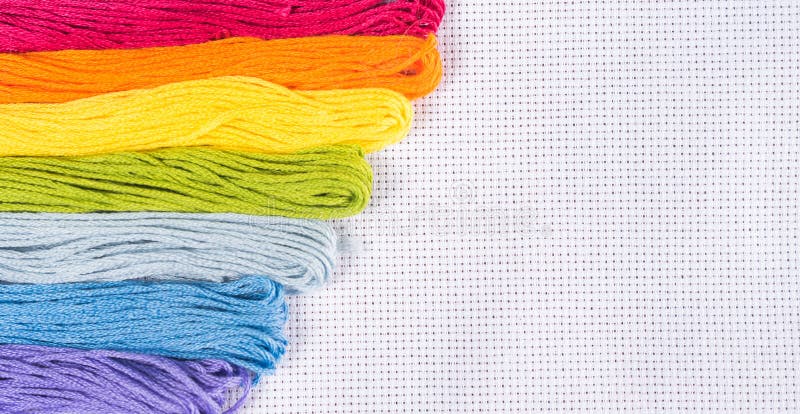 Barwiona nić dla broderii na białej kanwie Odbitkowy spase obrazy stock Barwiona nić dla broderii na białej kanwie Odbitkowy spase obrazy stock