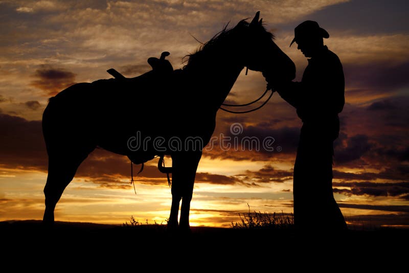 Basamento di tramonto del cavallo del cowboy fotografia stock libera da diritti Basamento di tramonto del cavallo del cowboy fotografia stock libera da diritti