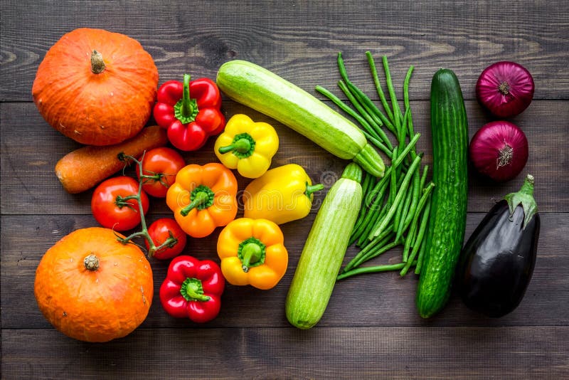 Base da dieta saudável Vegetais abóbora, paprika, tomates, cenoura, abobrinha, beringela na parte superior de madeira escura do f