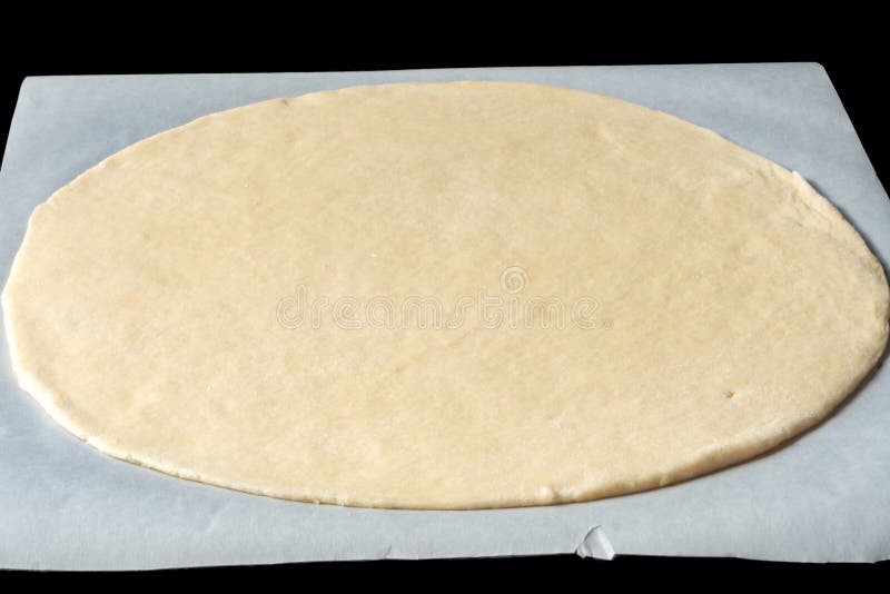 Base da pizza em um papel de cozimento