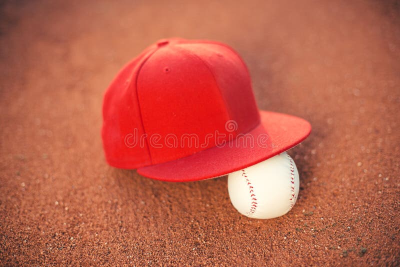 Baseball cap and ball on pitchers mound. Baseball cap and ball on pitchers mound.