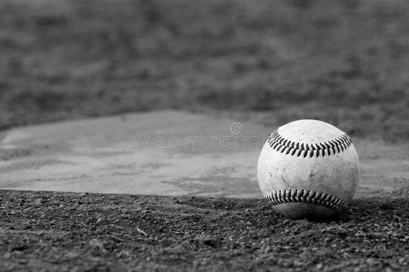 One baseball on home plate at a sports field. One baseball on home plate at a sports field