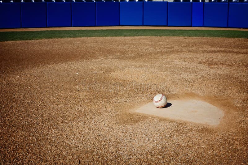 A baseball sitting on home plate. Great sports background with lots of copy space. A baseball sitting on home plate. Great sports background with lots of copy space.