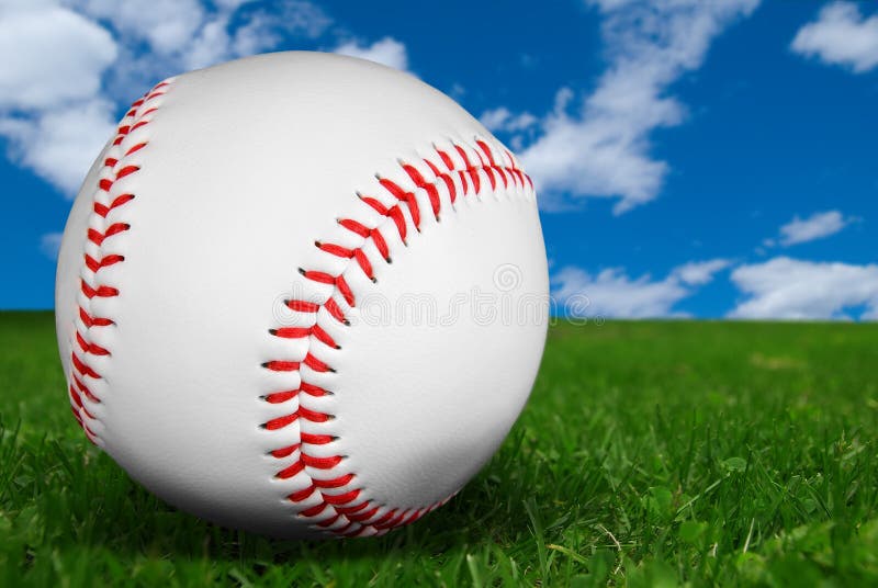 Baseball on grass isolated on a field of grass with a sky background
