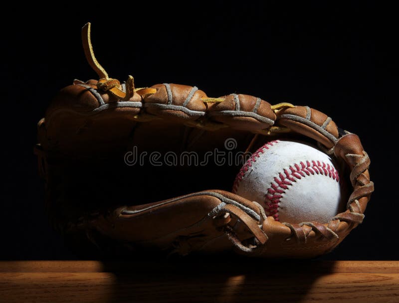 Baseball and mitt on a bench.