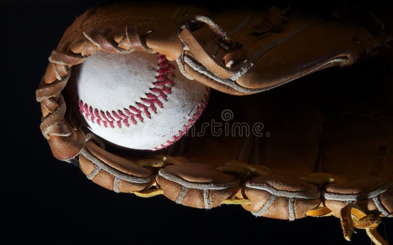Baseball in mitt on black royalty free stock photography