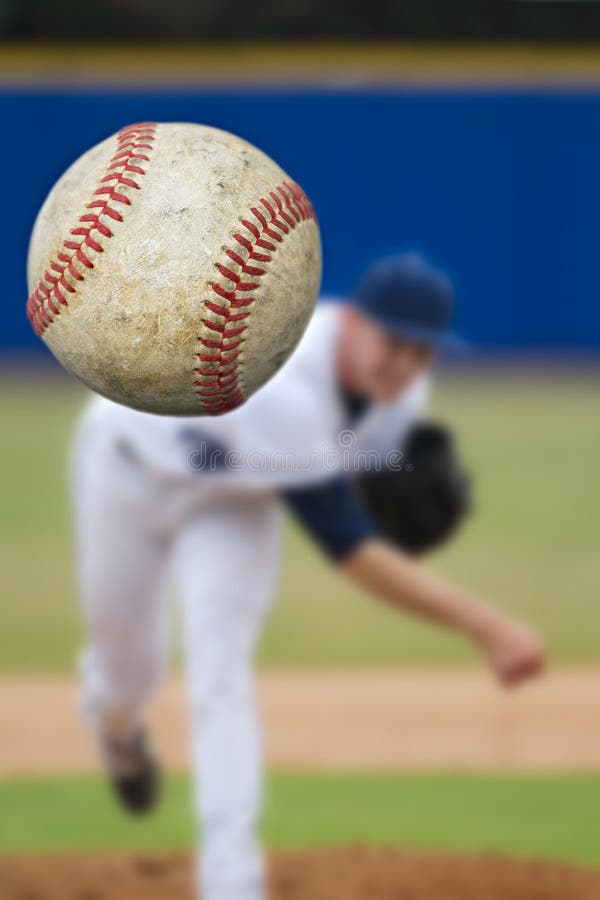 A baseball pitcher throwing a strike. Selective Focus on the ball coming into close view. Vertical composition