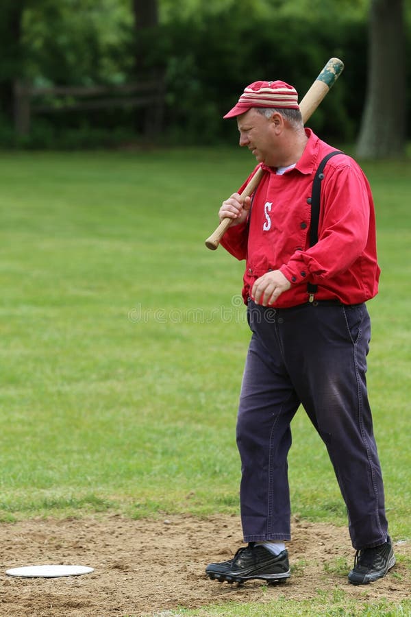 Baseball player in 19th century vintage uniform during old style base ball play stock image Baseball player in 19th century vintage uniform during old style base ball play stock image
