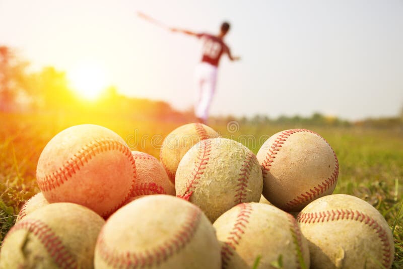 Baseball players practice wave a bat with balls in a field. Baseball players practice wave a bat with balls in a field