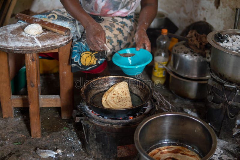 Basic African köks Kokning på branden Chapati - lokal mat royaltyfri bild