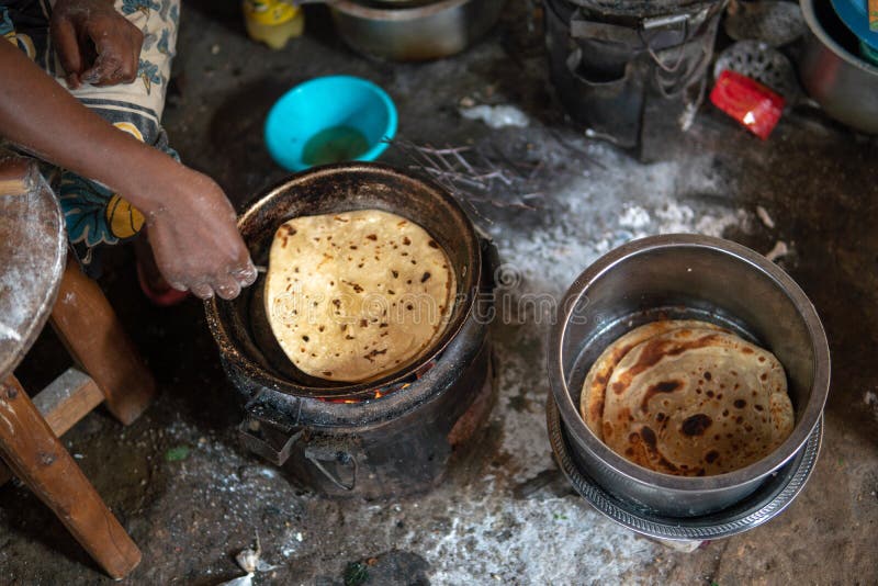 Basic African köks Kokning på branden Chapati - lokal mat arkivfoton
