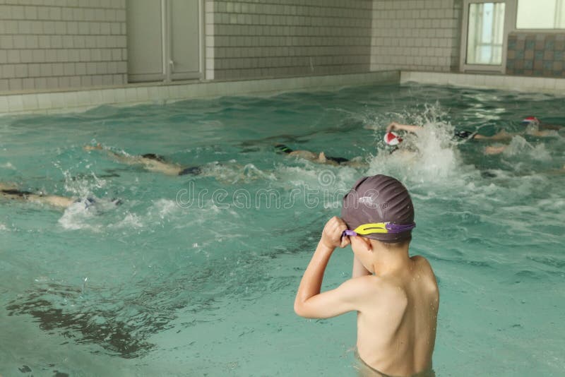 Basisschoolkinderen binnen het zwemmen vaardighedenles stock foto Basisschoolkinderen binnen het zwemmen vaardighedenles stock foto