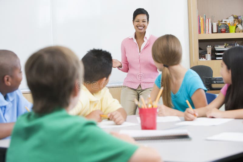 Basisschoolklaslokaal met leraar royalty-vrije stock afbeeldingen Basisschoolklaslokaal met leraar royalty-vrije stock afbeeldingen