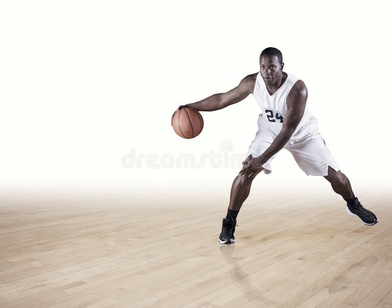 Baskeballspeler die op een hardhouthof druppelen stock afbeelding Baskeballspeler die op een hardhouthof druppelen stock afbeelding