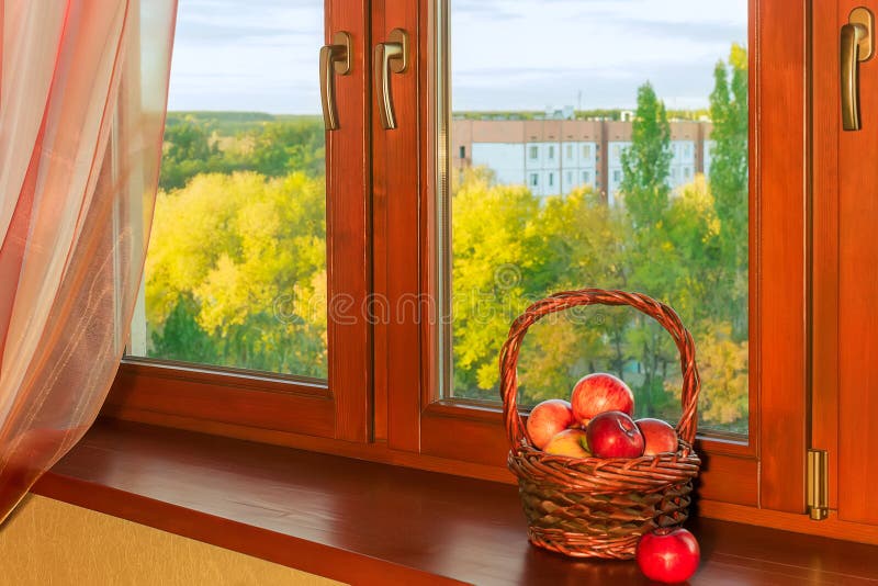 Basket with apples at wooden window in autumn