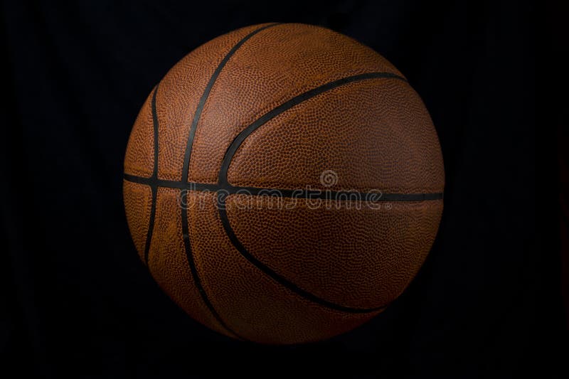 This is a used basketball on a black background. This is a used basketball on a black background