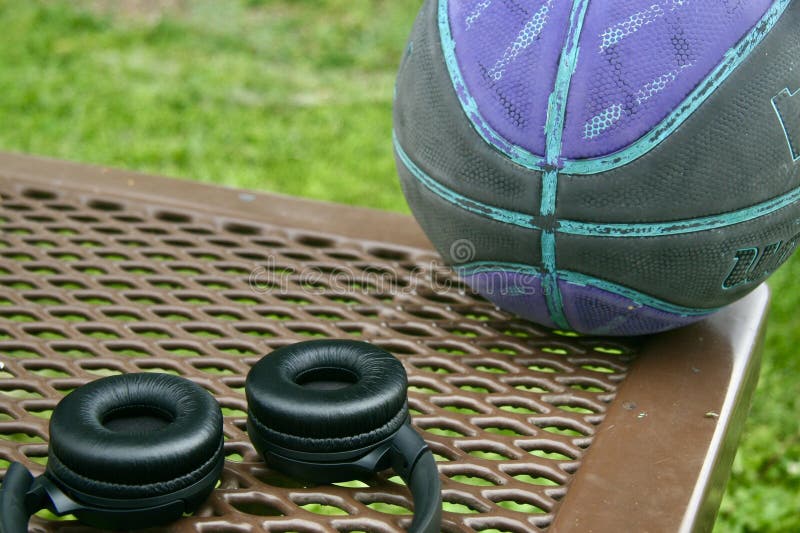 Basket e cuffie appoggiati sul tavolo del parco fotografia stock
