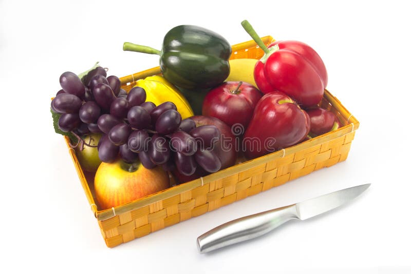 Basket of Fake Fruit with a Knife on a White Background. Stock Photo