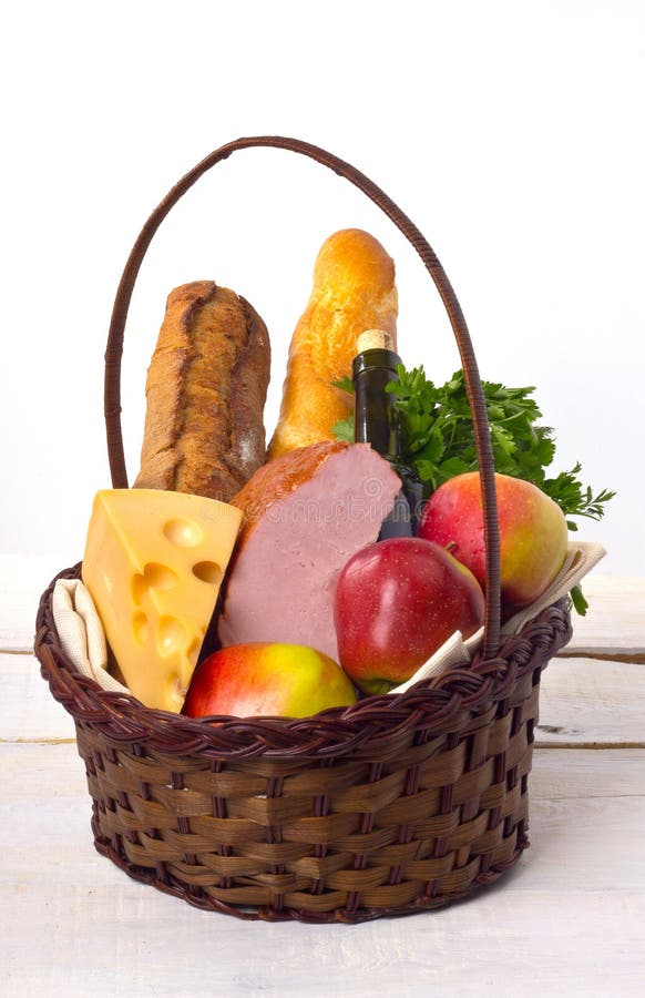 Basket with food for a picnic on a wooden table