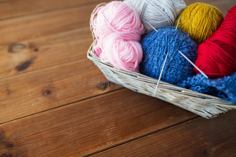 Basket with knitting needles and balls of yarn