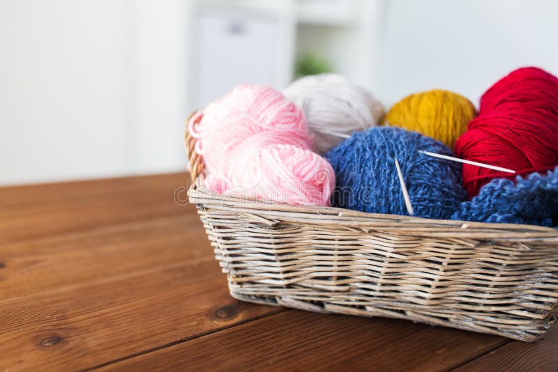 Basket with knitting needles and balls of yarn