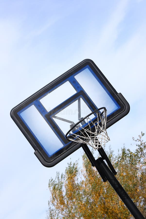 An outdoor basketball goal photographed against a cloudy blue sky. An outdoor basketball goal photographed against a cloudy blue sky.