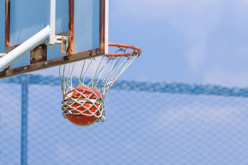 Basketball Going into the Hoop at a Local Basketball Game Stock Photo