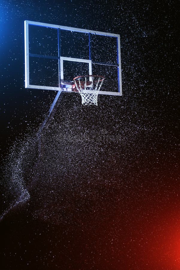 Basketball hoop on black. Basketball arena under rain. Lightened by mixed color lights.