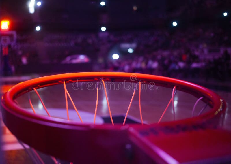 basketball hoop in red neon lights in sports arena during game