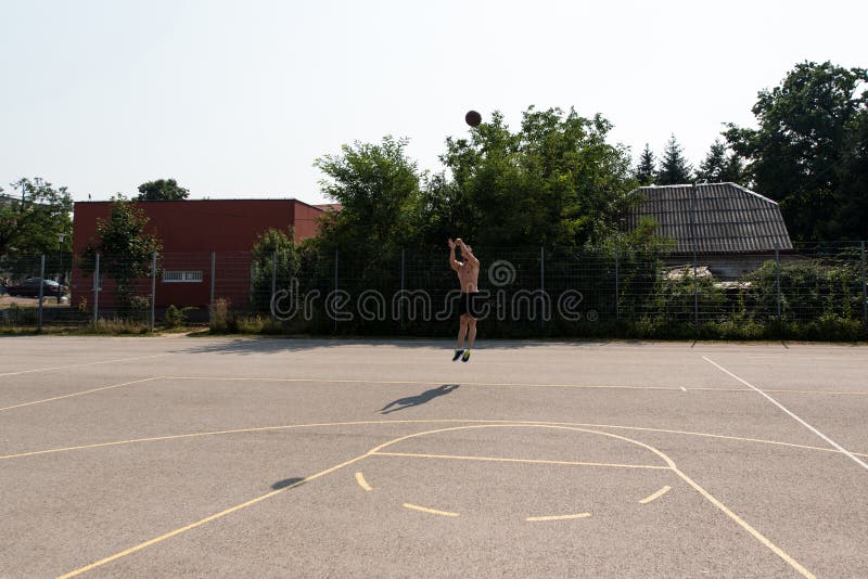 Basketball Player Shooting In A Playground stock photography