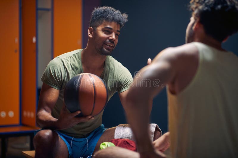 Basketball Players Sitting on Bench Facing Each Other and Having a