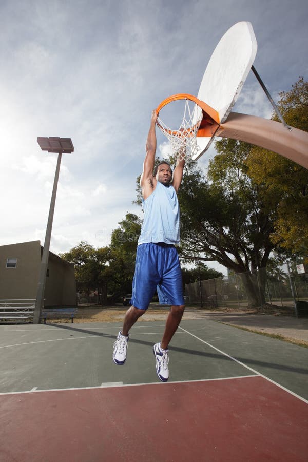 Basketspelare som hänger från beslag fotografering för bildbyråer
