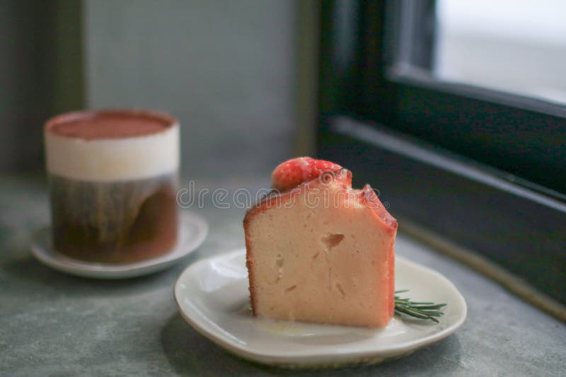 Basque burnt cheesecake with fresh strawberries on white plate cement floor background. Japanese dessert