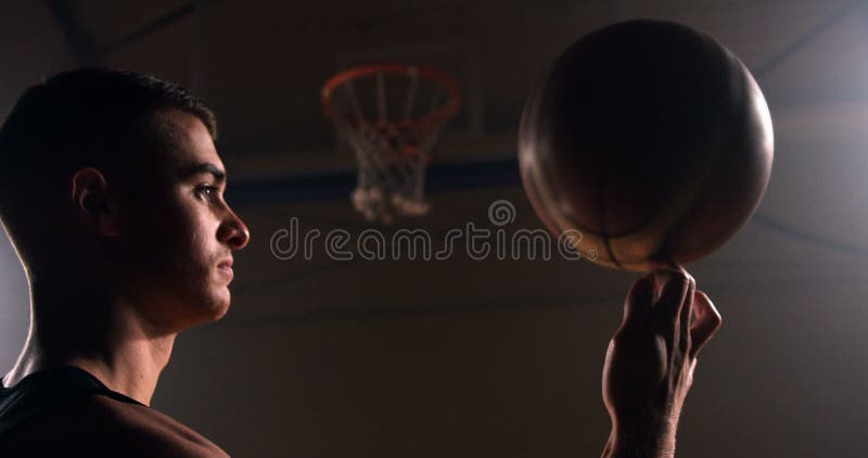 Girando a bola de basquete laranja em um dedo.