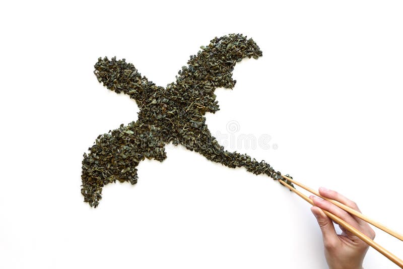 Bastoncini a disposizione che tengono drago dalla coda fatta da tè verde asciutto su fondo bianco Concetto minimo, creativo o del fotografie stock Bastoncini a disposizione che tengono drago dalla coda fatta da tè verde asciutto su fondo bianco Concetto minimo, creativo o del fotografie stock