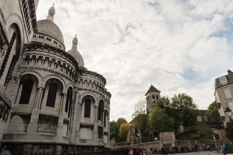 Basílica de Sacre Couer y la iglesia de Montmartre del Saint Pierre de Paroisse en París, Francia, con las calles circundantes fotografía de archivo Basílica de Sacre Couer y la iglesia de Montmartre del Saint Pierre de Paroisse en París, Francia, con las calles circundantes fotografía de archivo